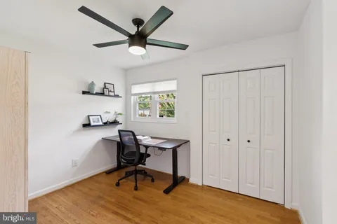 a view of a workspace with furniture and a window