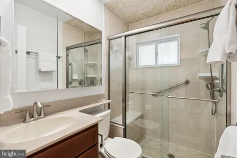 a bathroom with a sink toilet a mirror and shower