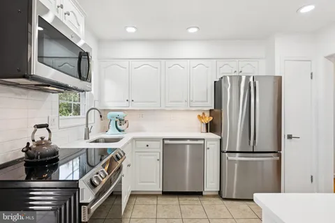 a kitchen with stainless steel appliances a refrigerator sink and cabinets