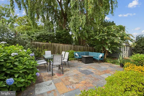 a view of backyard with a table and chairs and potted plants