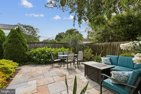 a view of a patio with couches table and chairs and potted plants