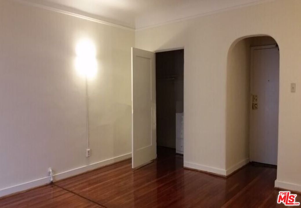 665 South Cochran Avenue, Unit 104 Los Angeles, CA 90036 - Photo 2 of 8 an empty room with wooden floor and closet