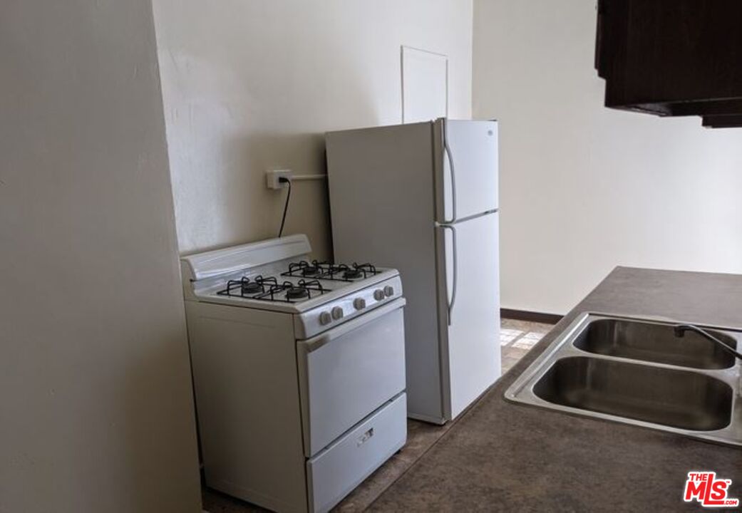 665 South Cochran Avenue, Unit 104 Los Angeles, CA 90036 - Photo 5 of 8 a kitchen with a stove and a refrigerator