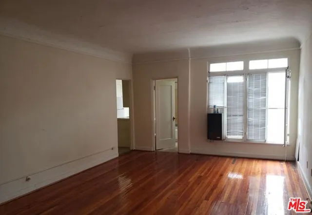 wooden floor in an empty room with a window