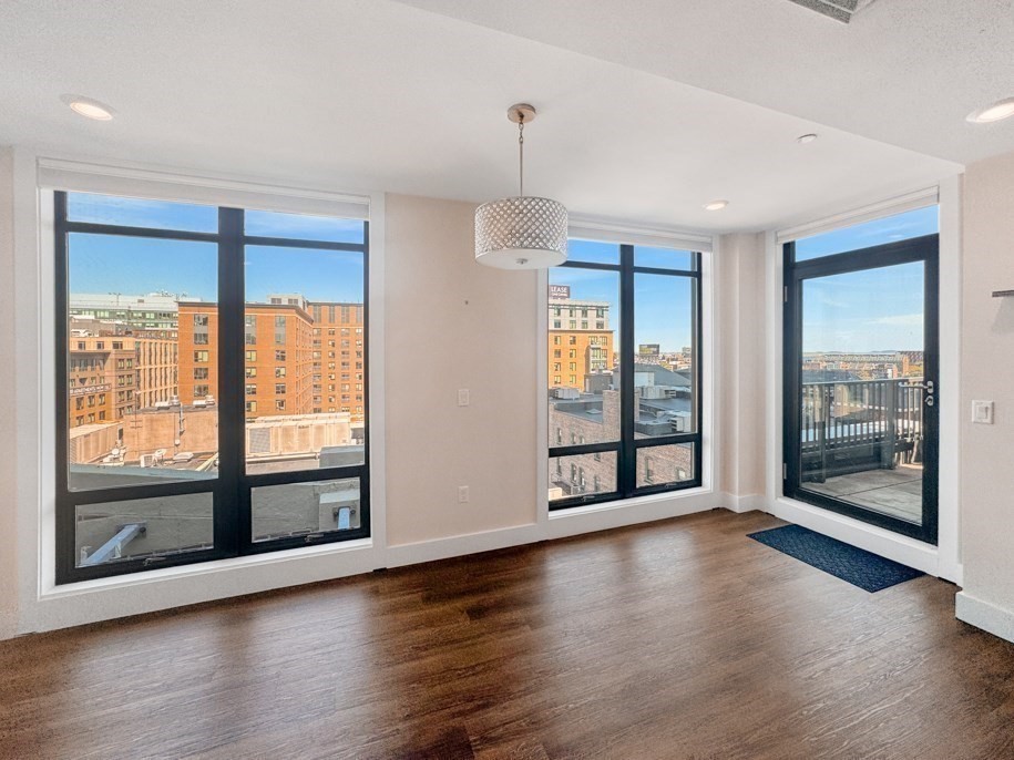 121 Portland Street, Unit 902 Boston, MA 02114 - Photo 8 of 25 a view of an empty room with wooden floor and a window