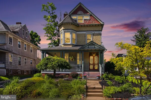 a view of a house with a small yard plants and large tree
