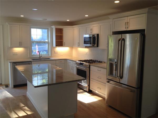 9 Ripley Street, Unit 4 Newton, MA 02459 - Photo 2 of 2 a kitchen with stainless steel appliances granite countertop a refrigerator a stove and a sink with wooden floor