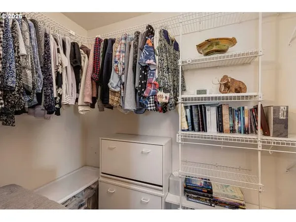 a view of walk in closet with clothes and shoes