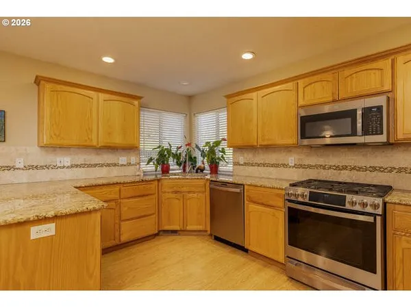 a kitchen with stainless steel appliances granite countertop a stove a sink and a microwave