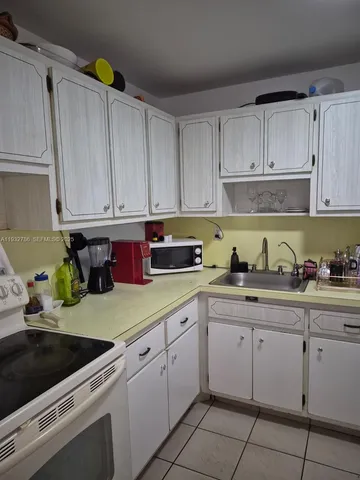 a kitchen with a sink window and cabinets