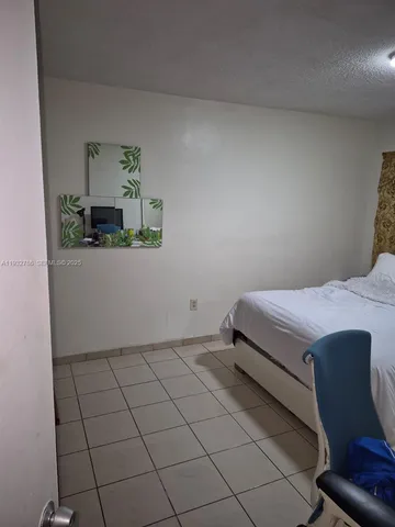 a bedroom with a bed and a potted plant