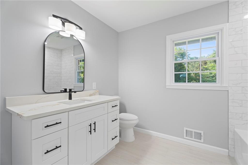 1939 Wee Kirk Road Southeast Atlanta, GA 30316 - Photo 22 of 43 a bathroom with a toilet sink and mirror