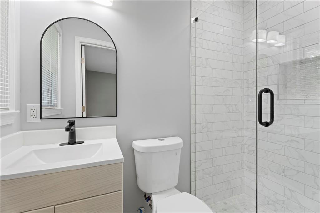 1939 Wee Kirk Road Southeast Atlanta, GA 30316 - Photo 29 of 43 a bathroom with a sink a toilet and a mirror