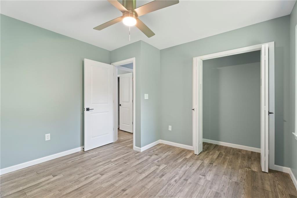 1939 Wee Kirk Road Southeast Atlanta, GA 30316 - Photo 33 of 43 an empty room with wooden floor and a ceiling fan