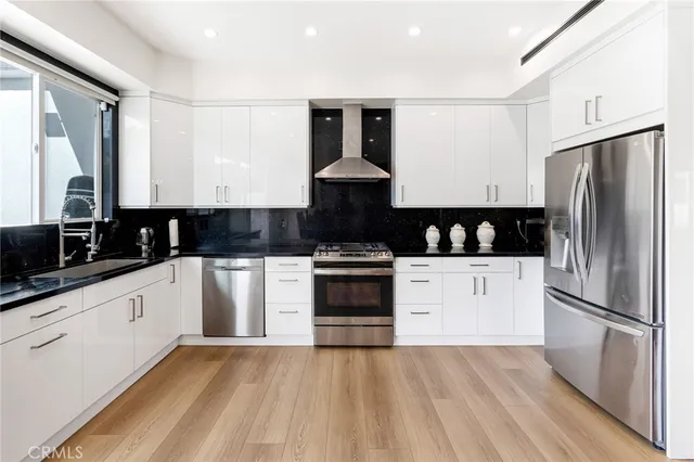 a kitchen with granite countertop a refrigerator stove and sink