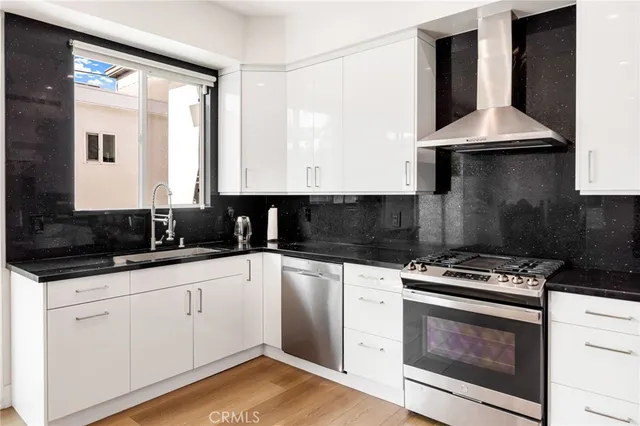 a kitchen with granite countertop white cabinets and black appliances