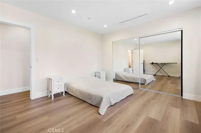 a bedroom with a bed and a large mirror