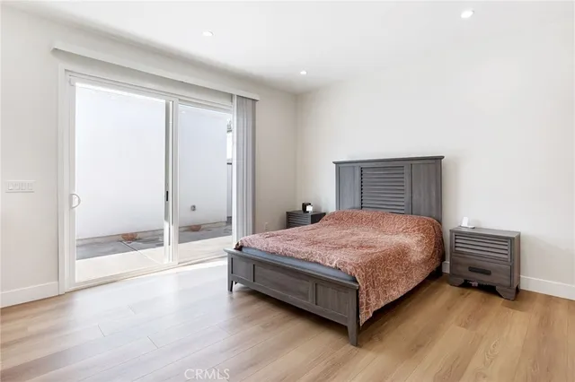 a spacious bedroom with a bed and wooden floor