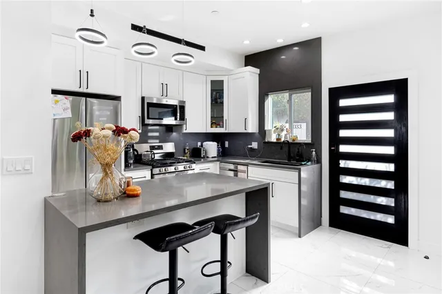 a kitchen with granite countertop a sink stainless steel appliances and cabinets