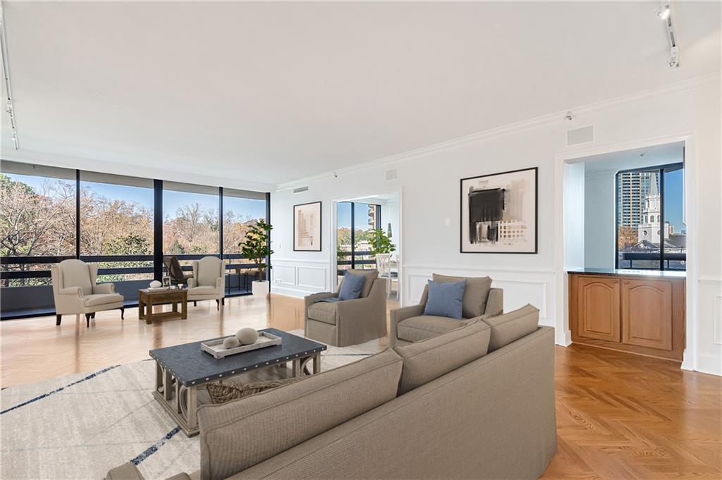 Welcome to Park Place on Peachtree!  Home #8D is a lovely light filled one bedroom with a beautiful open floor plan and neutral palette throughout.  Experience the incredible views with floor to ceiling windows!  On the right side of this photo is the dining room and an opening to the kitchen.  This photo has been virtually staged. 