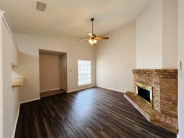 a view of empty room with wooden floor and fireplace