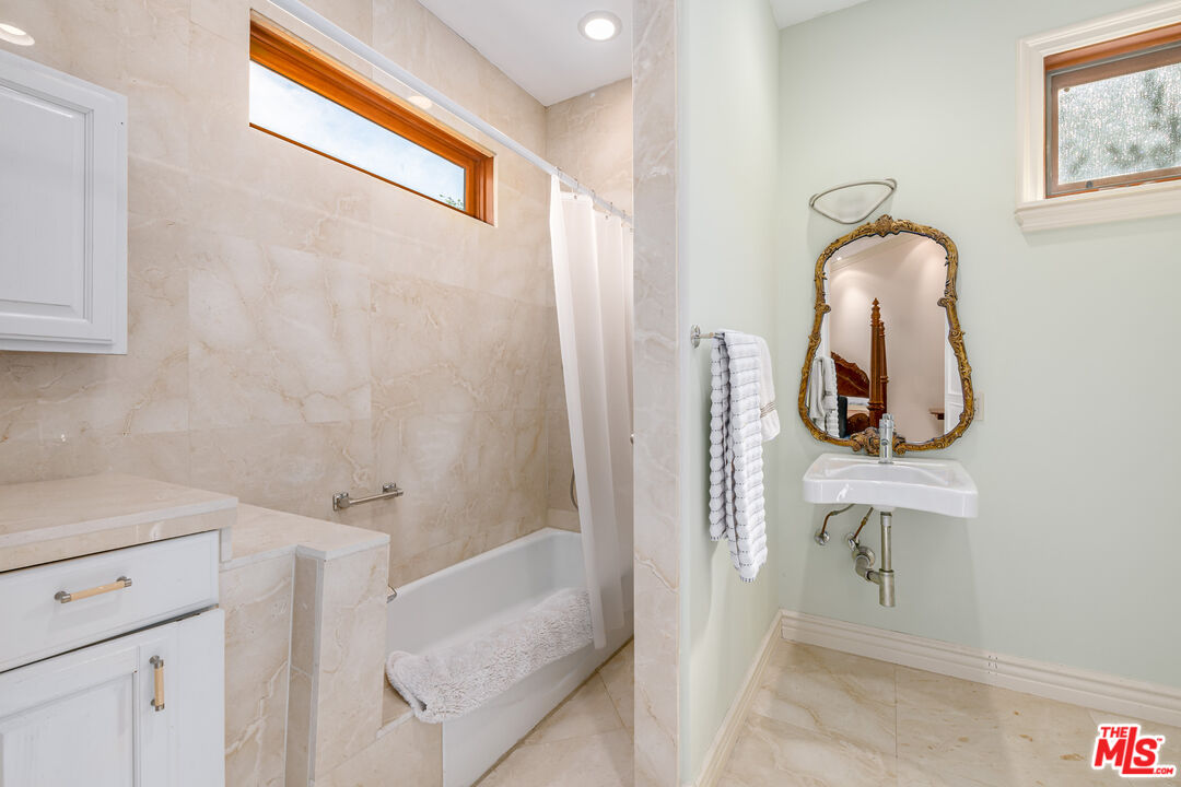 936 Kenfield Avenue Los Angeles, CA 90049 - Photo 13 of 30 a bathroom with a sink and a mirror
