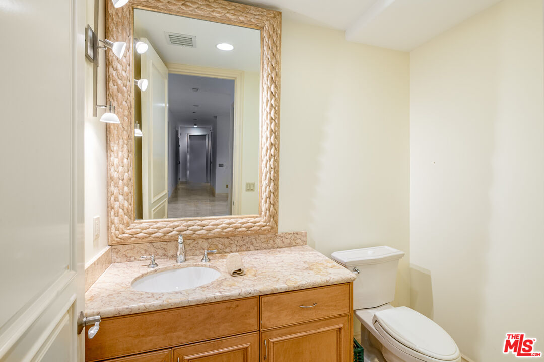 936 Kenfield Avenue Los Angeles, CA 90049 - Photo 15 of 30 a bathroom with a granite countertop sink mirror vanity and toilet
