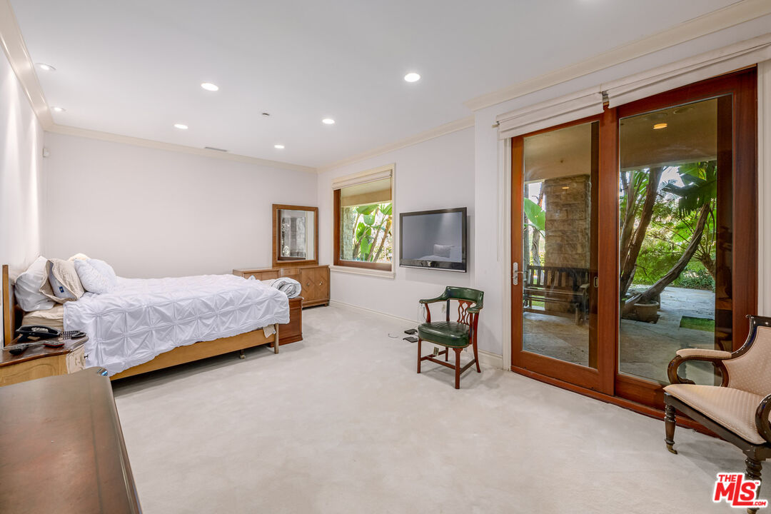 936 Kenfield Avenue Los Angeles, CA 90049 - Photo 16 of 30 a bedroom with a bed and large window