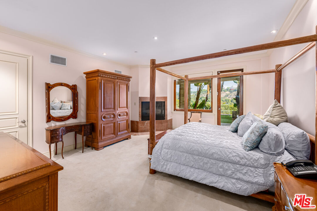 936 Kenfield Avenue Los Angeles, CA 90049 - Photo 18 of 30 a bedroom with a bed and wooden floor