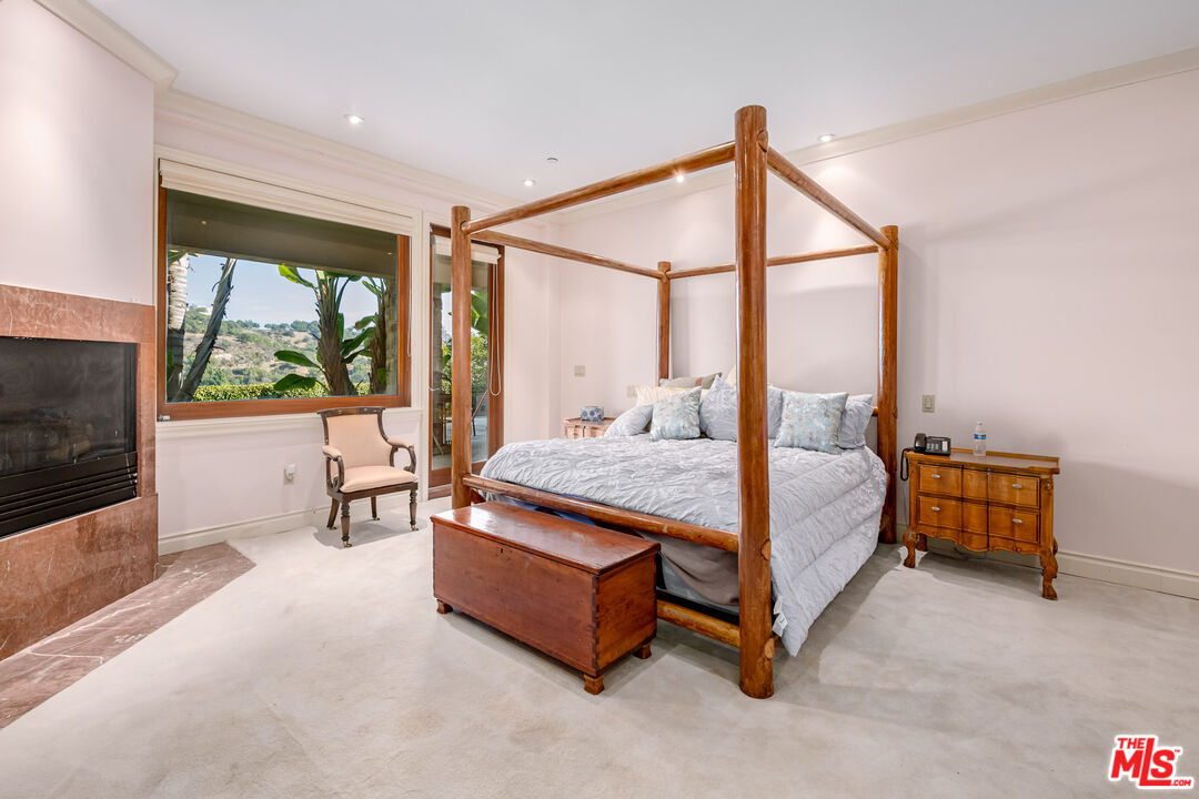 936 Kenfield Avenue Los Angeles, CA 90049 - Photo 19 of 30 a bedroom with a bed and large window