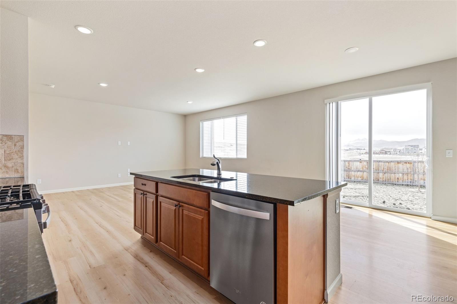 2771 Big Empty Place Berthoud, CO 80513 - Photo 9 of 25 a kitchen with stainless steel appliances granite countertop a sink and wooden floor