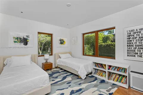 a bedroom with a bed a large window and book shelf