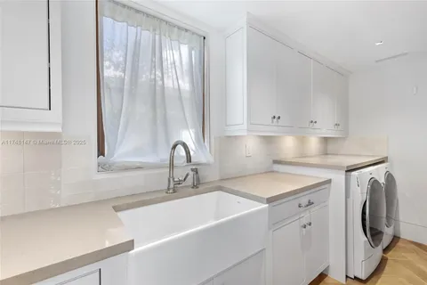 a kitchen with a sink cabinets and a washer dryer