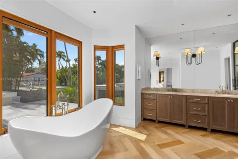 a spacious bathroom with a large tub sink and glass door