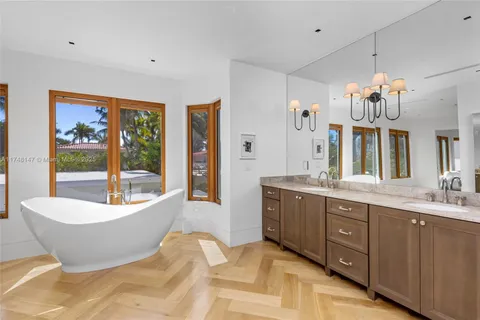 a spacious bathroom with a tub double sink and mirror