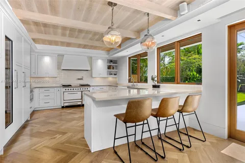 a kitchen with stainless steel appliances granite countertop a stove a sink dishwasher and a refrigerator with wooden floor