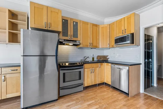 a kitchen with granite countertop a refrigerator stove top oven and sink