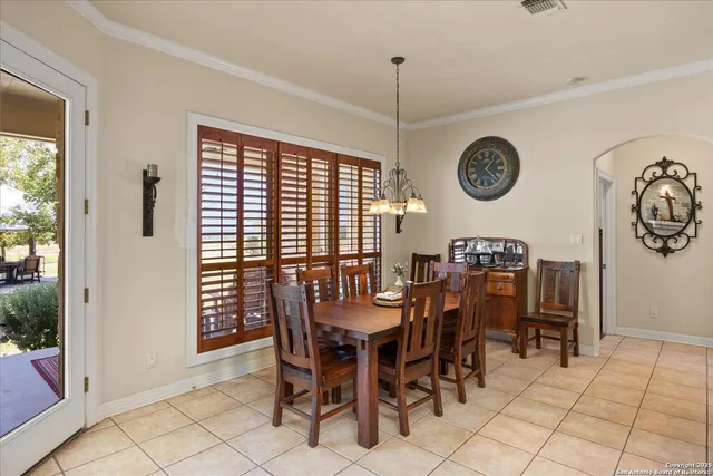 a dining room with furniture a chandelier and wooden floor