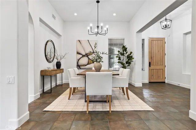 a dining room with furniture potted plants and wooden floor
