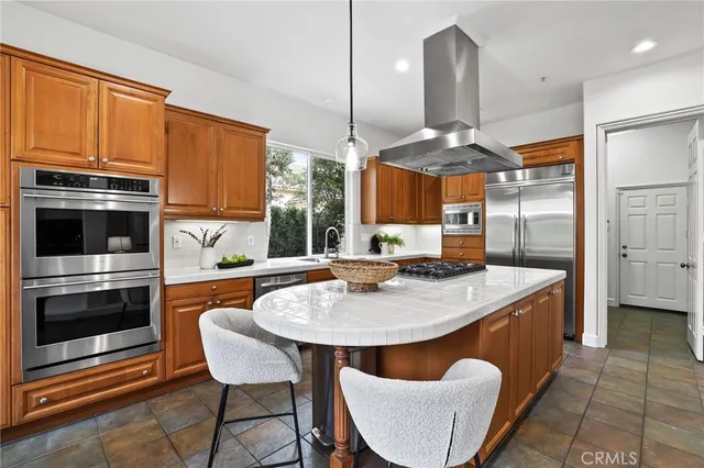 a kitchen with a sink a counter space appliances and cabinets