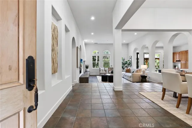 a living room with furniture a chandelier and a dining table
