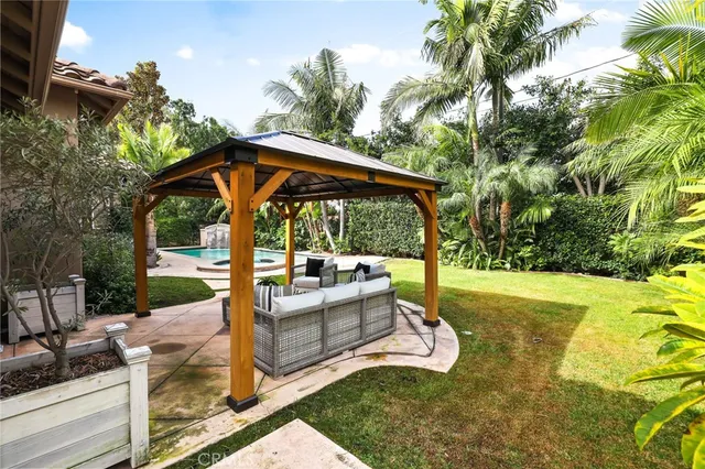 a view of a patio with table and chairs potted plants and palm tree