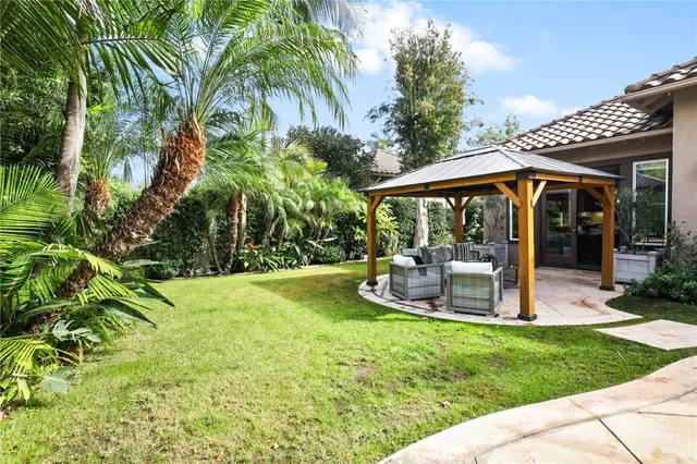 a view of a backyard with plants and a fountain