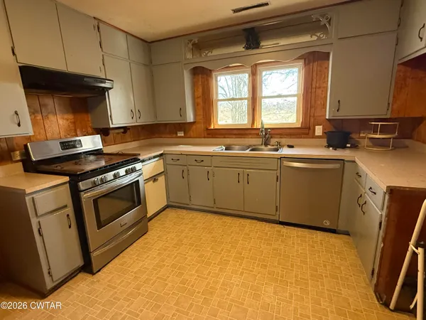 a kitchen with a sink stove and cabinets
