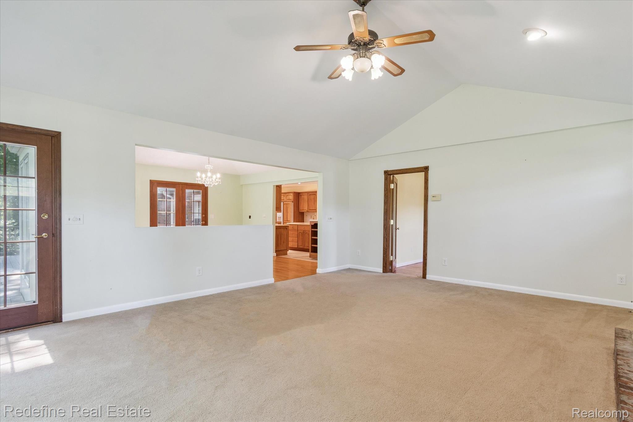 3777 Dorr Road Brighton, MI 48116 - Photo 27 of 77 Carpeted empty room featuring vaulted ceiling, ceiling fan, and a chandelier