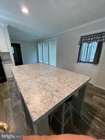 a view of kitchen island with sink microwave and refrigerator