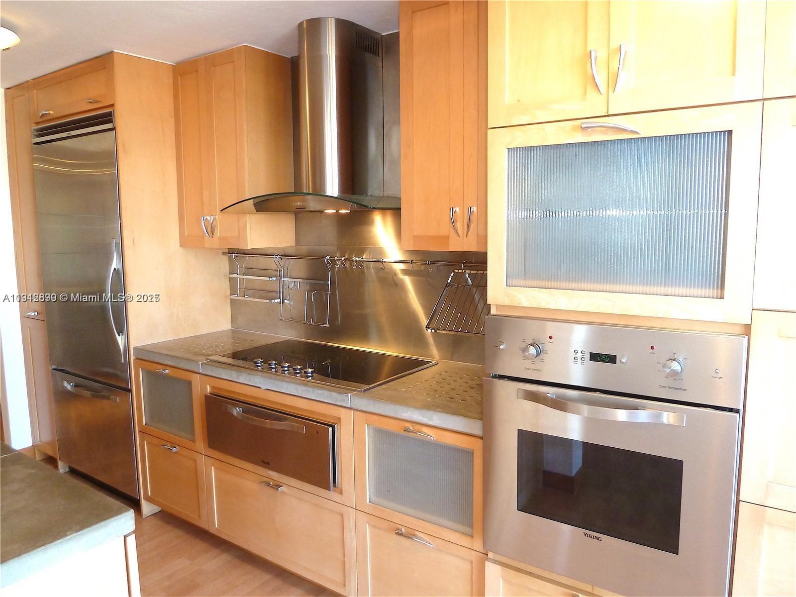 1688 West Avenue, Unit 405 Miami Beach, FL 33139 - Photo 13 of 23 a kitchen with granite countertop white cabinets and white appliances
