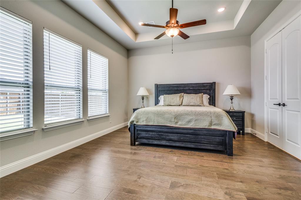 11112 Lacey Oak Ridge Flower Mound, TX 76226 - Photo 21 of 40 a bedroom with a large bed and a chandelier