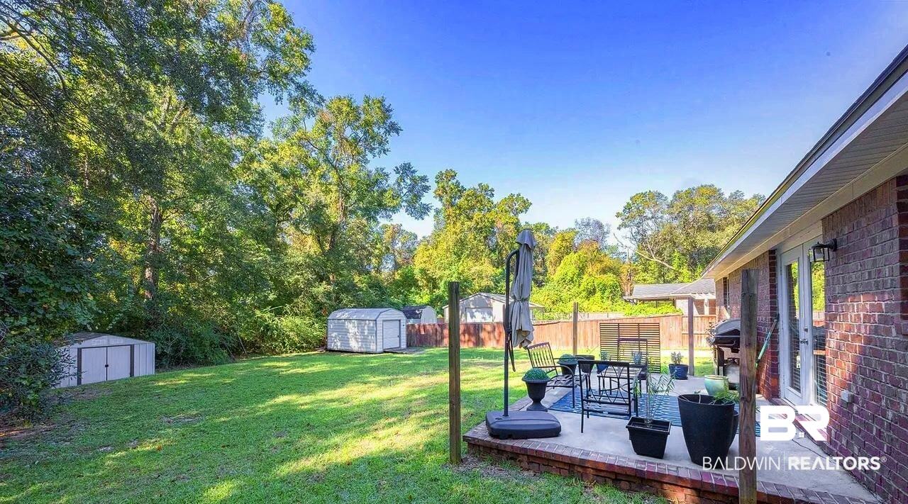 12230 Bromley Road Stapleton, AL 36578 - Photo 27 of 34 Fenced backyard featuring a shed, a patio area, and view of scattered trees