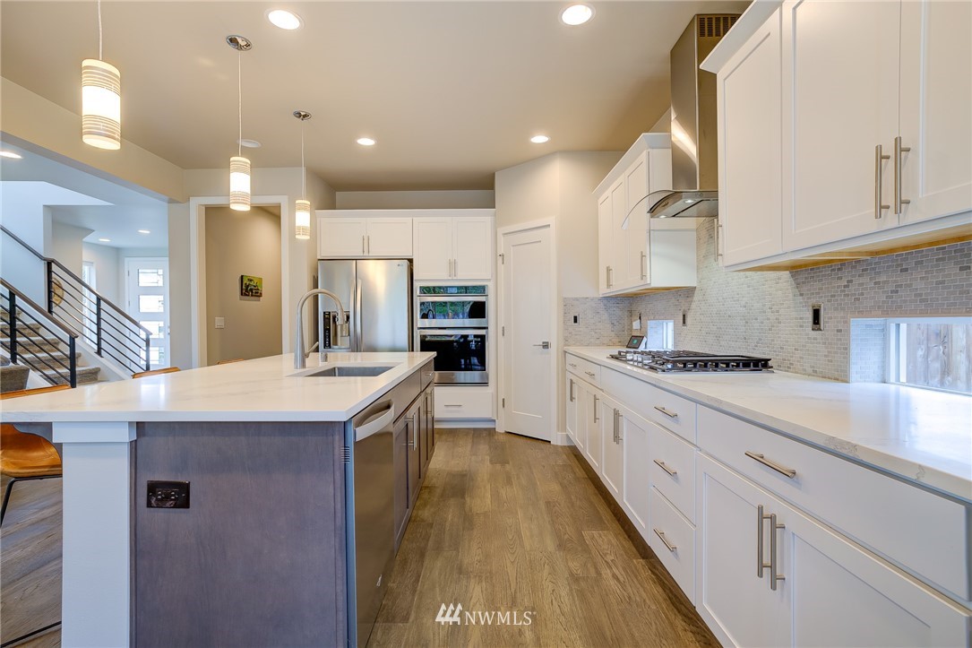 4792 Smithers Avenue South Renton, WA 98055 - Photo 13 of 37 a large kitchen with stainless steel appliances kitchen island a large counter top and a stove